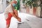 Man with white hair ties his shoelaces on a city tour. Senior retired enjoying fitness and walking