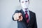 Man in white mask in business suit pointing fingers at