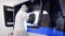 A man in a white protective suit stands near a large 3D printer