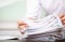 Man in a white shirt sign contract agreement documents in Stack of Group report papers clipped in color clips in fair light,