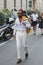 Man with white shirt and trousers walking before Versace fashion show, Milan Fashion Week street