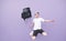 Man in a white T-shirt jumping with a backpack on a purple background