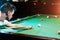 A man in a white T-shirt is playing billiards, a dark background. Pleasant pastime, entertainment, leisure, family holidays, games