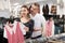 Man with wife participate in inspection of goods, help determine choice of blouse