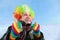 Man in wig of clown looks in sky