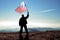 Man winner waving Liberia flag on top of the mountain peak