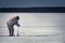 A man on a winter fishing drill hole ice drill