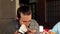 A man wipes his mouth with a napkin during lunch at a restaurant.