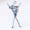 A man of wire is standing, raising his hands up, symbolizing success, joy, dream