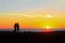 Man and woman admire the colorful sunset on the beach