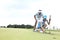 Man with woman aiming ball on golf course against sky