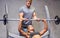 Man and woman with barbell flexing muscles in gym