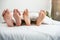 Man and woman barefeet lying in the bed