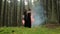 Man and a woman in black robes standing in the woods