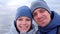 Man and woman bloggers on selfie video smiling and talking at sea in winter.