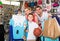 man and woman with boy choosing t-shirts and other goods in sport shop