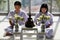 Man and woman Buddhist in white dress sitting and doing meditation in front of set of altar table with buddha image. Idea for