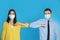 Man and woman bumping elbows to say hello on blue background. Keeping social distance during coronavirus pandemic