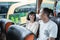 a man and woman chatting and laughing while sitting on the bus