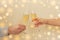 Man and woman cheers with champagne glasses on beige background