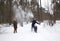 Man, woman, child joyfully throws snow with hands. Love winter