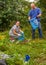 A man and a woman clean up a garbage dump in the nature.