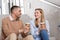 Man and woman with coffee talking at office stairs