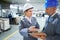 Man, woman and conversation with clipboard in warehouse for quality inspection or safety checks and process monitoring