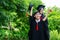 A man and woman couple dressed in black graduation gown or graduates with congratulations with graduation hats is standing,