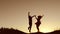 Man and woman couple in love silhouette jumping in slow motion video. Man and woman joy running sunlight and jumping on