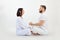 Man and woman, couple in love, wear white outfit, practice Pilates and yoga, sit in lotus pose. Conscious tantra love