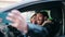 Man and woman couple make selfie on the smartphone sitting on car at street