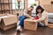 Man and woman couple packing fragile cardboard box at new home