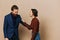 Man and woman couple in a relationship smile and interaction on a beige background in a real relationship between people