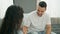 Man and woman couple sitting on sofa kissing hand speaking at home