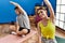 Man and woman couple smiling confident stretching at sport center