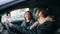 Man and woman couple speaking driving car at street