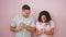 Man and woman couple standing together dancing over isolated pink background