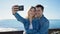 Man and woman couple standing together make selfie by smartphone at seaside