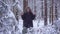 Man and woman couple is throwing snowballs to each other together in a snow winter forest. young man plays snowballs in