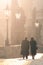 Man and woman couple walk on Charles Bridge in foggy morning, Prague, Czech Republic. Romantic Prague theme