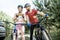 Man and woman cyclists with smartphone on the forest road