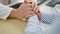 Man and woman doctor and patient with hands together at clinic