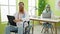 Man and woman doctors sitting on table and wheelchair working at clinic