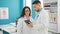 Man and woman doctors standing together using touchpad at the clinic