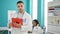 Man and woman doctors taking notes working smiling at the clinic