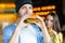 Man and woman eating burger. Young girl and young man are holding burgers on hands