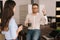 Man and woman employees standing with coffee cups and talking in office room