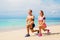 A man and woman exercising on the beach