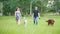Man and woman - family couple with pets dogs walking in park - irish setter and husky
